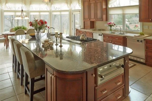 Kitchen with large granite island and bay windows by Masterpiece Kitchens