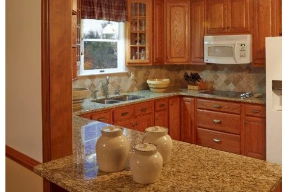 Oak cabinet kitchen with granite countertops and tile backsplash
